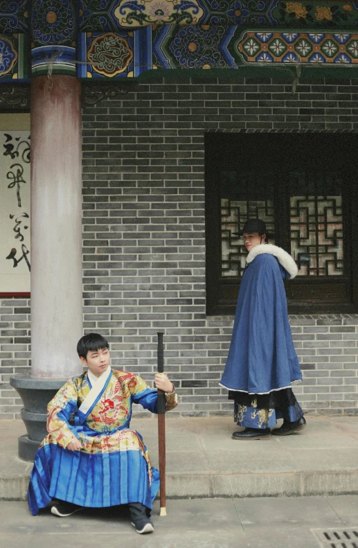a woman sitting on a step near the ground and a man