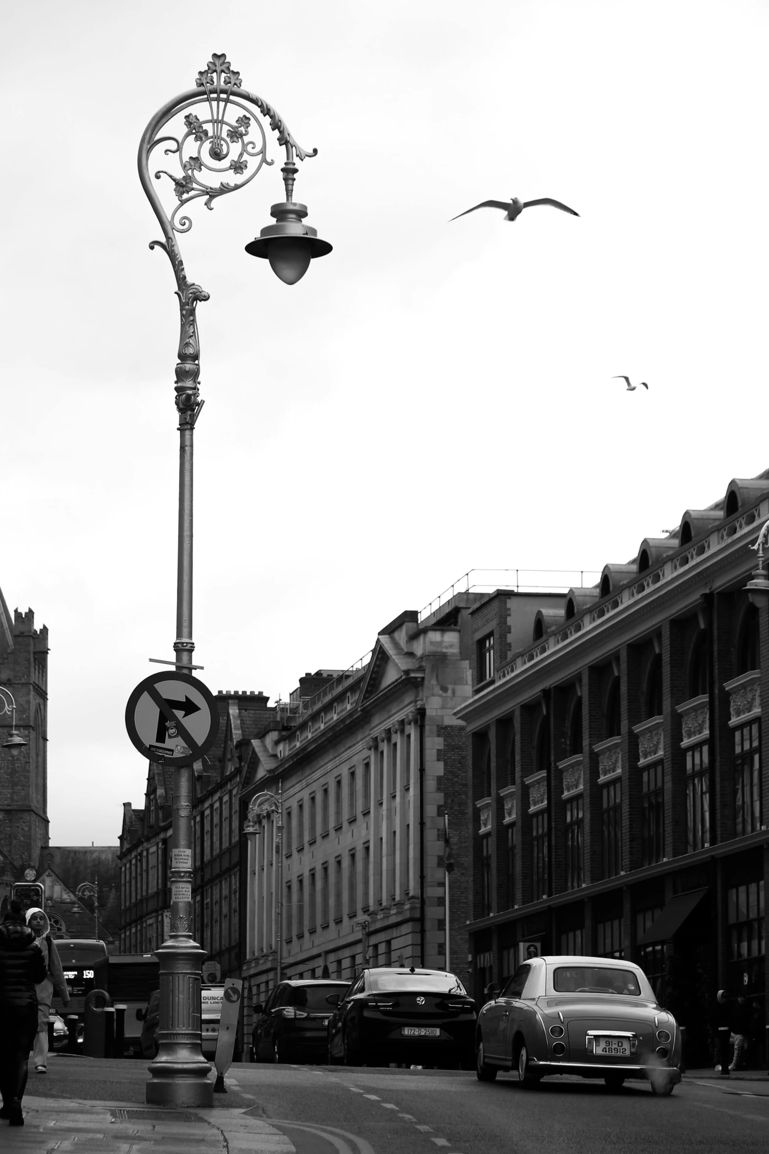 a man walking through a town street next to a light pole