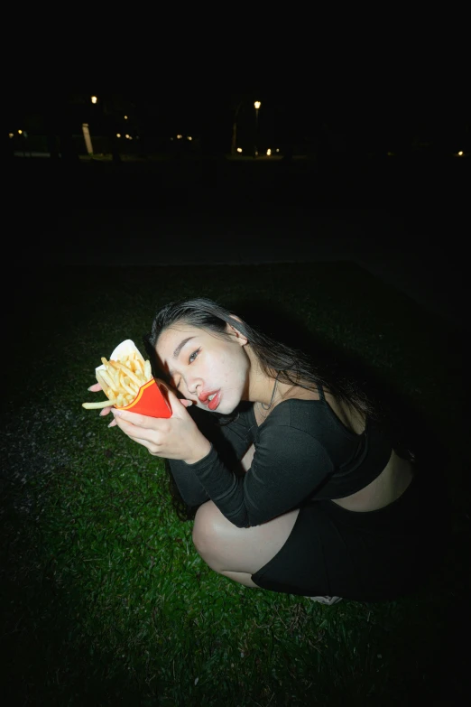 a woman is eating a dog and holding onto her french fries