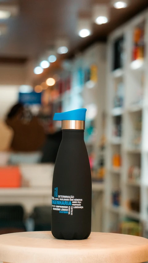 a black and blue colored metal water bottle on a wood table