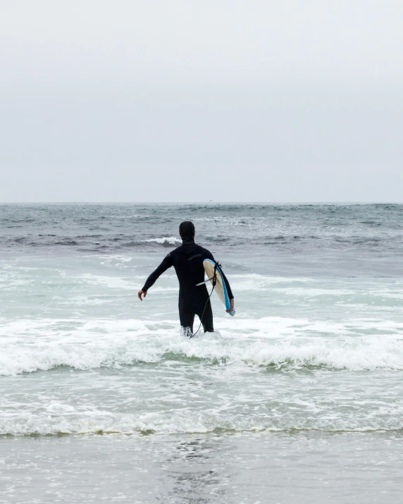 man standing in the water with his surf board