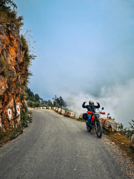 a man is celeting on the motorcycle as it drives past him