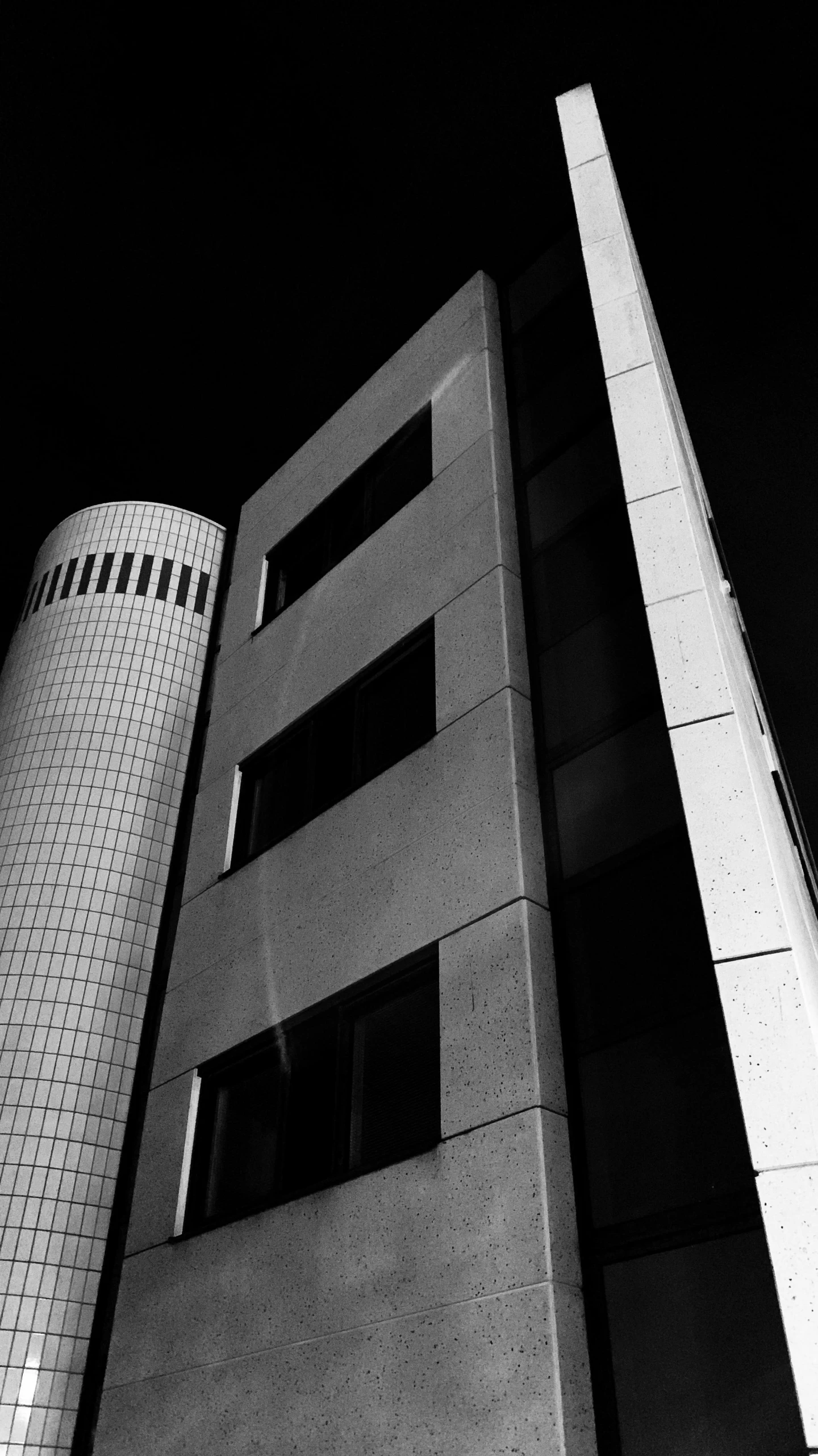 black and white pograph of two buildings in the dark