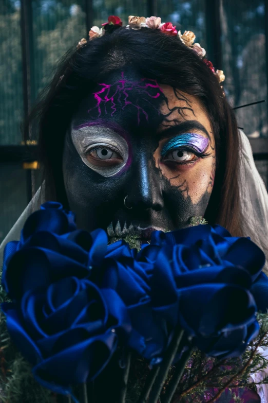 woman with blue roses in her face and dress