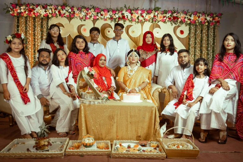 people dressed in traditional indian attire are gathered around a table