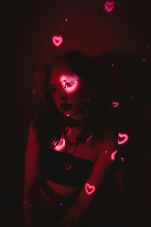 young woman in red light with red heart backdrop