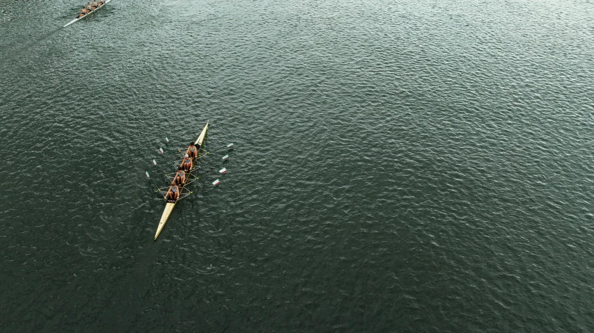 a large group of people in long boats on a body of water