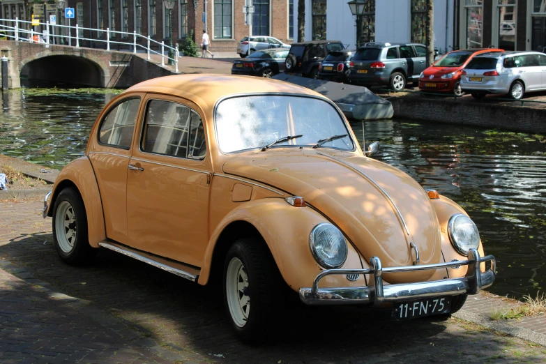 a car is parked near the water in front of some houses