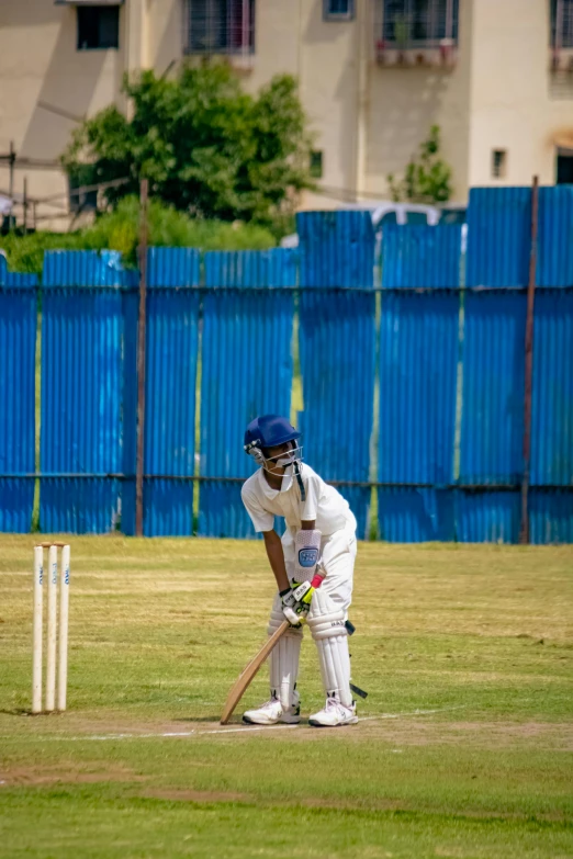 a man in blue and white cricket uniform prepares to swing at a ball