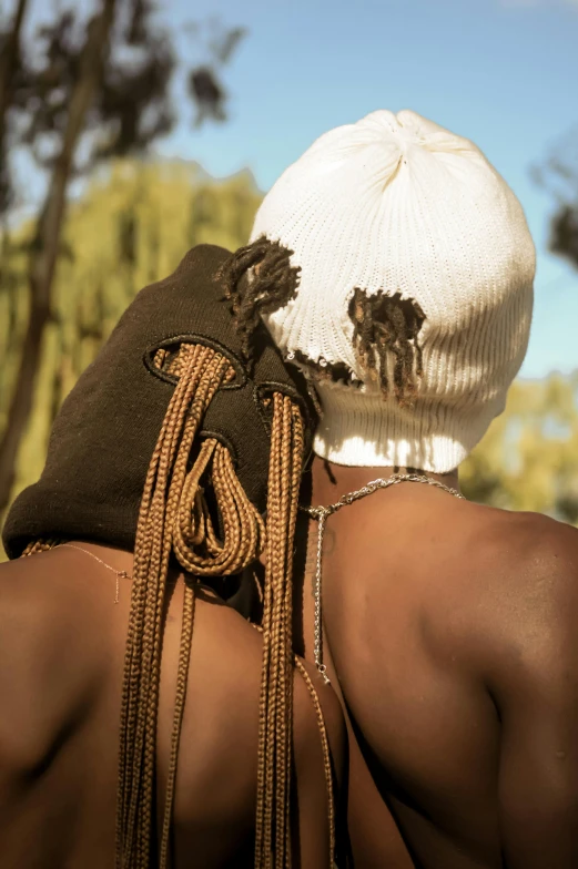 a person in white and black wearing ids, with a sweater over his head