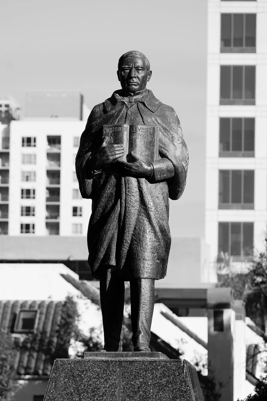 a sculpture of a man is seen in front of a tall building