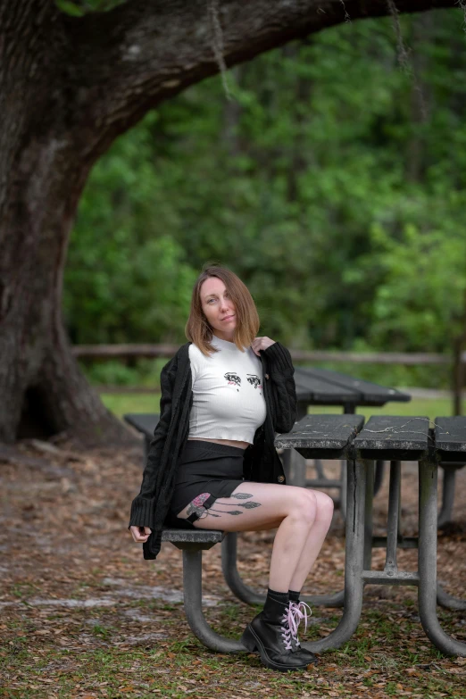 young woman posing at picnic table outdoors on a rainy day