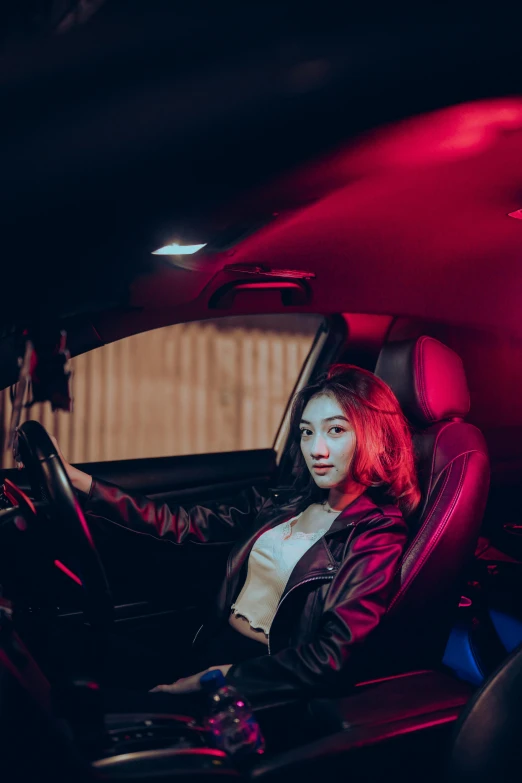 a woman sitting in a red leather car