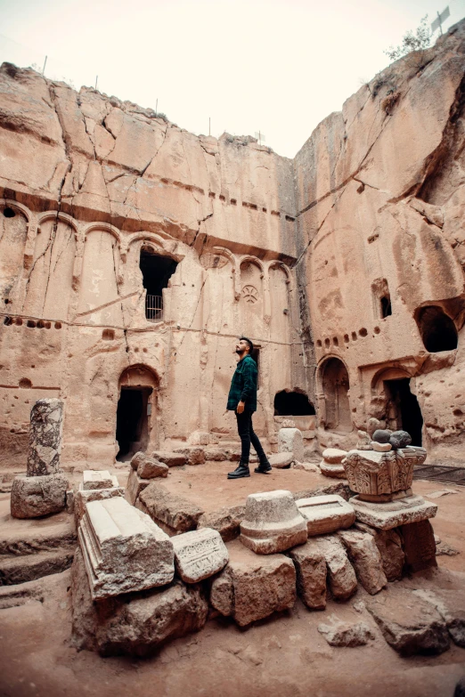 a man with a hat is standing in a cave