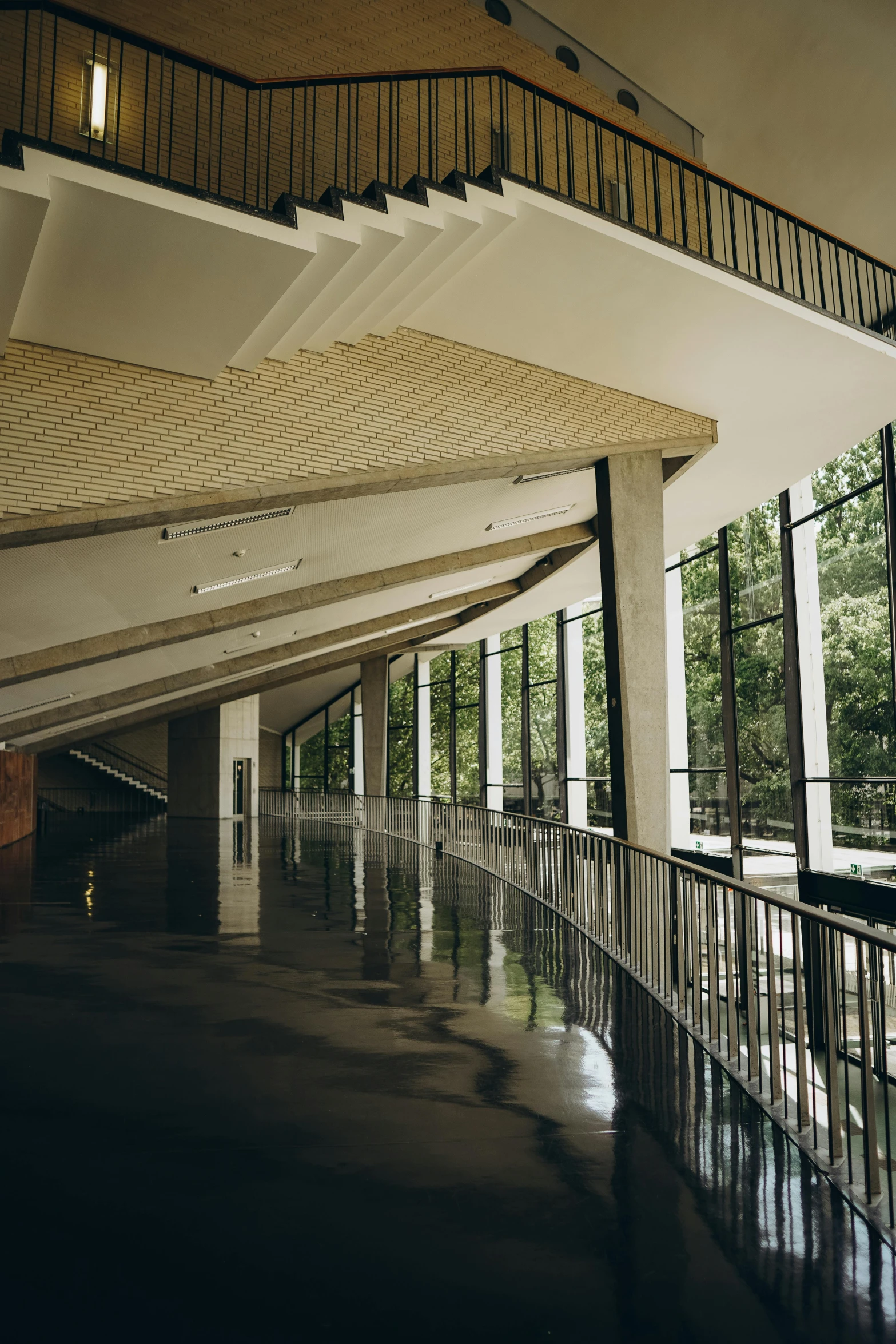 a walkway in front of large windows with a wooden balust