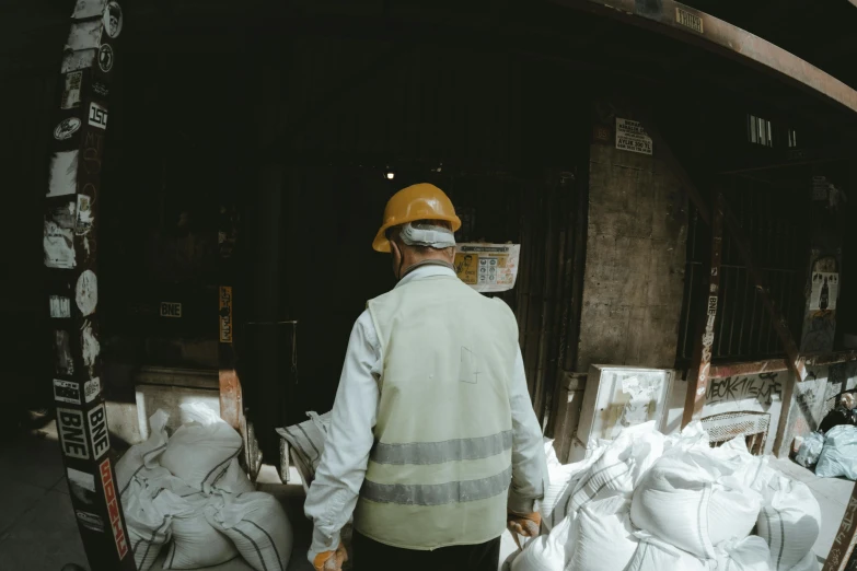 a person in a safety helmet walks around with bags