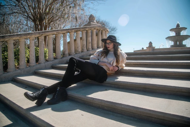 there is a woman sitting on the steps and holding her hands out