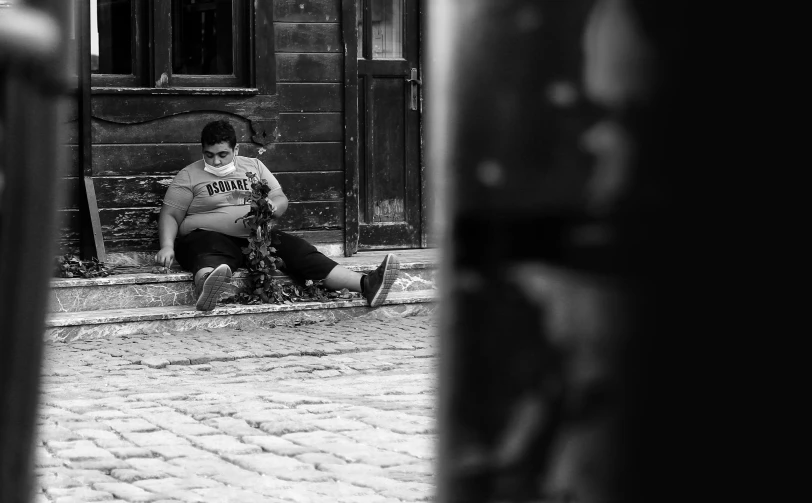 a woman that is sitting on a sidewalk