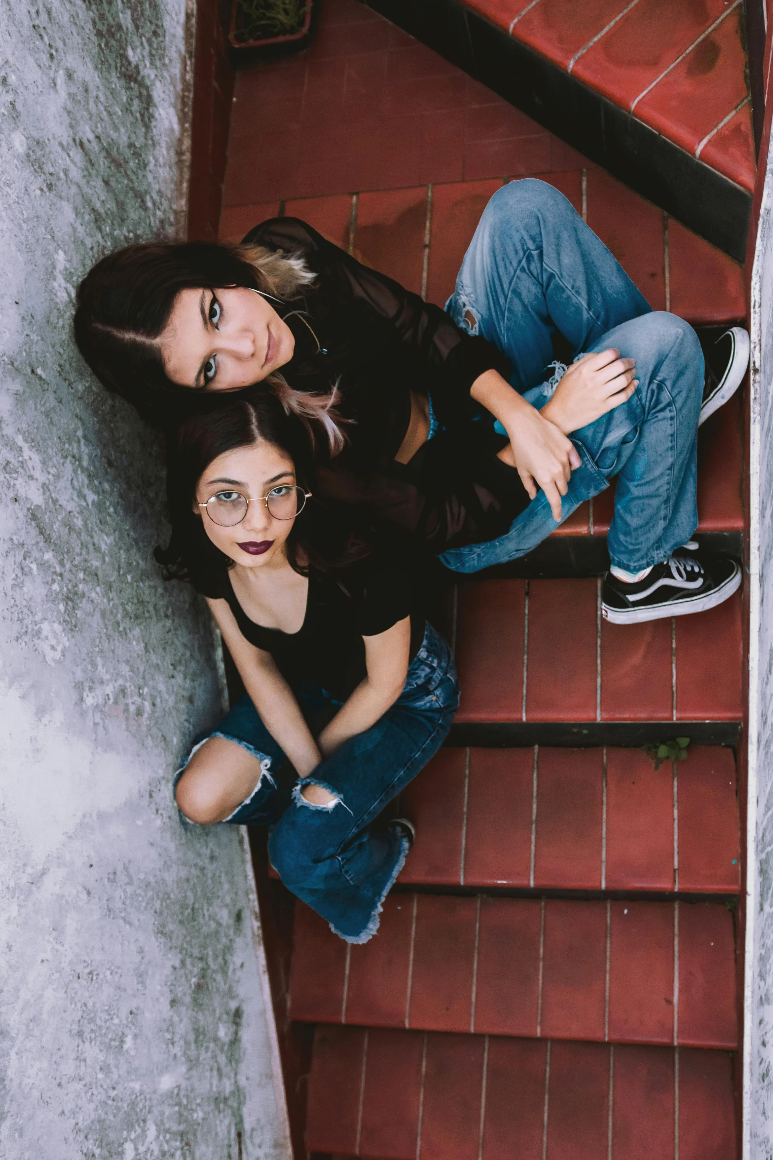 two women are standing on some steps with their arms around one another