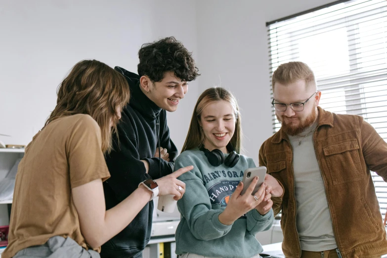 group of people standing around each other looking at soing