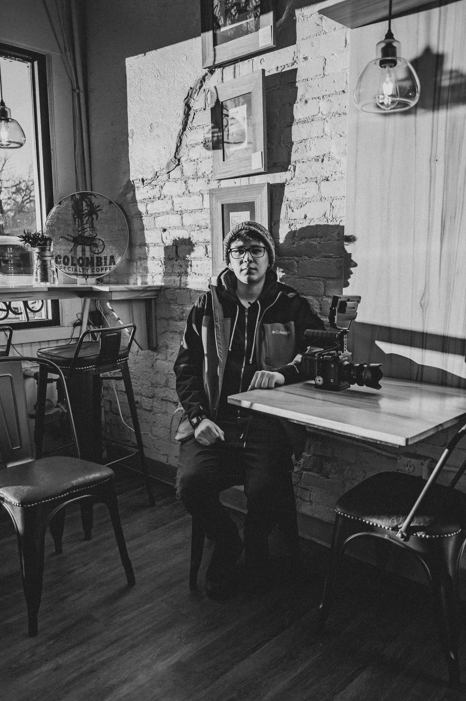 black and white image of a woman at a table in an old - fashioned shop