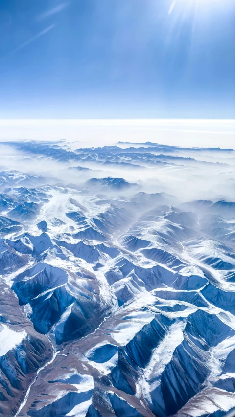 the mountains are surrounded by clouds and sunlight