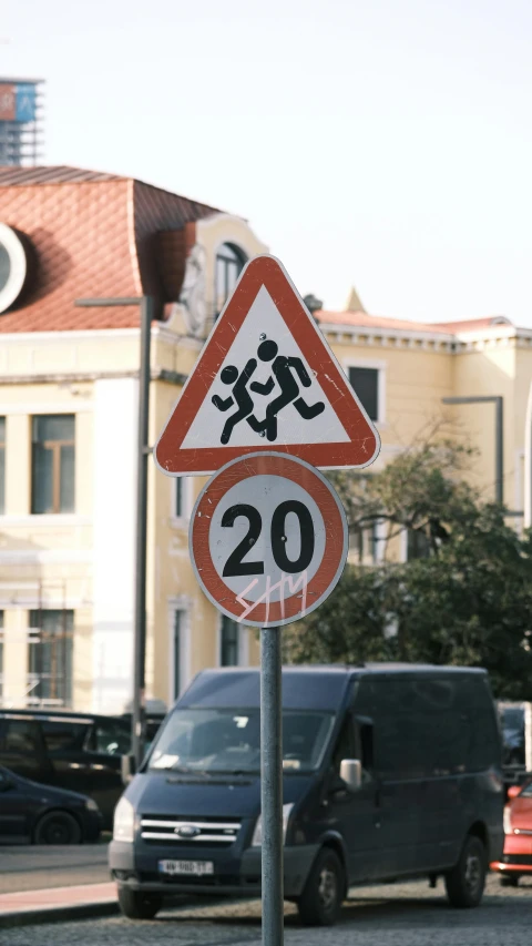 a triangular sign on a road with stickers in front