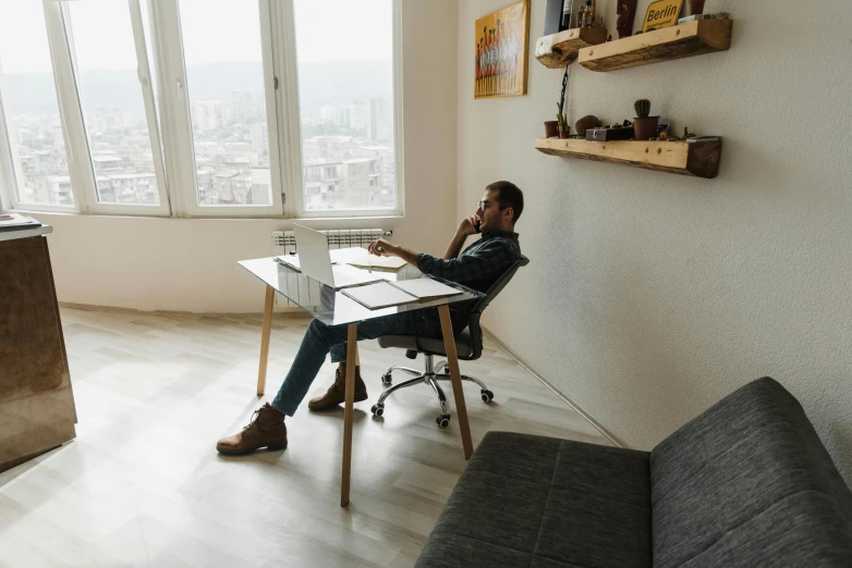 a man is sitting at a computer table and is looking at soing