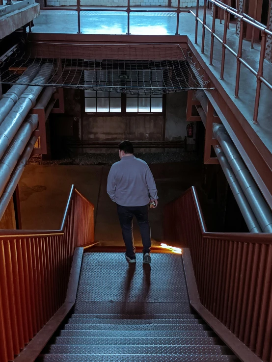 the man is walking down the stairs to the subway car