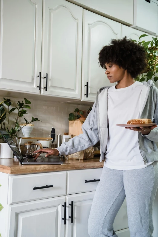 a woman standing in a kitchen preparing food