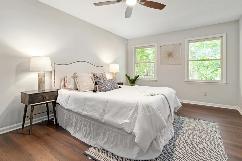 white bed in large bedroom with wooden floors