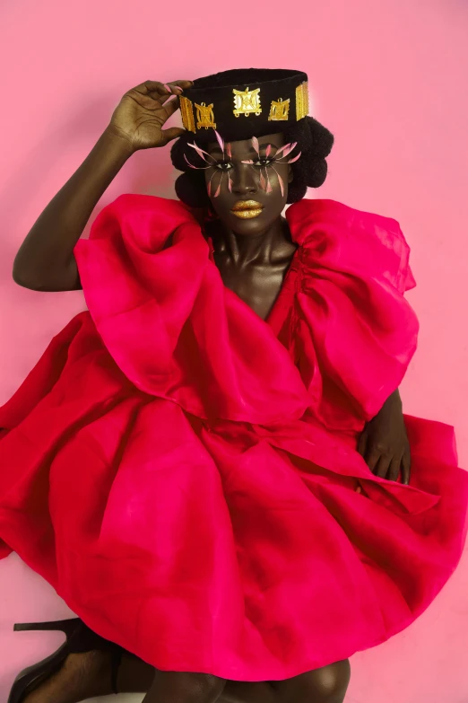 a black man in a pink dress and a black mask