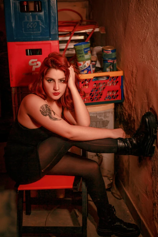 young woman posing with one leg propped up on red chair