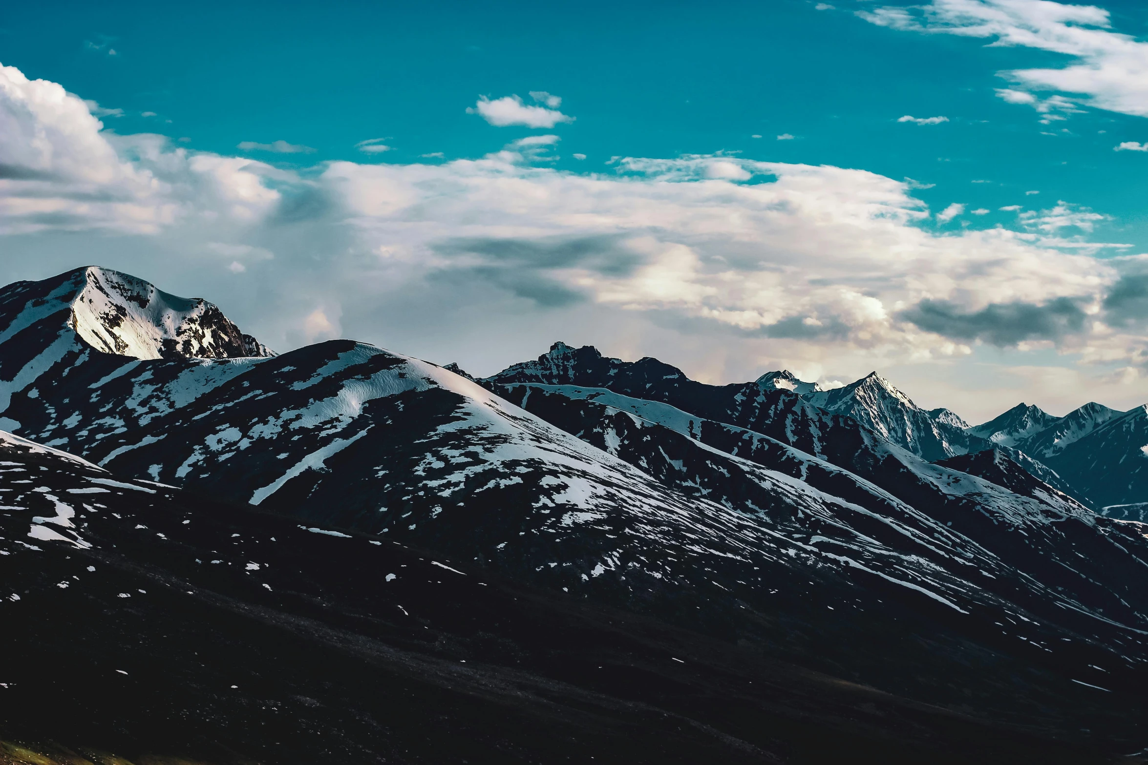 the snow capped mountains are under a blue sky