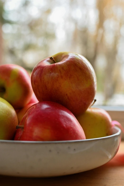 there are apples in a bowl on the table