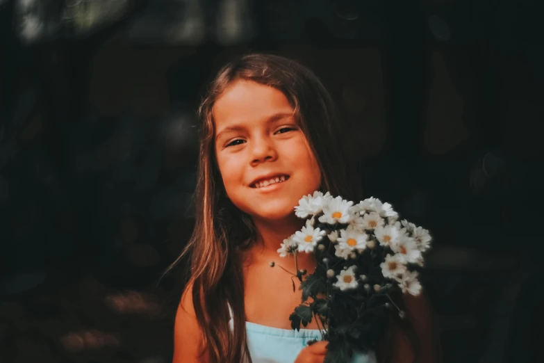 the girl is holding flowers outside posing for a po