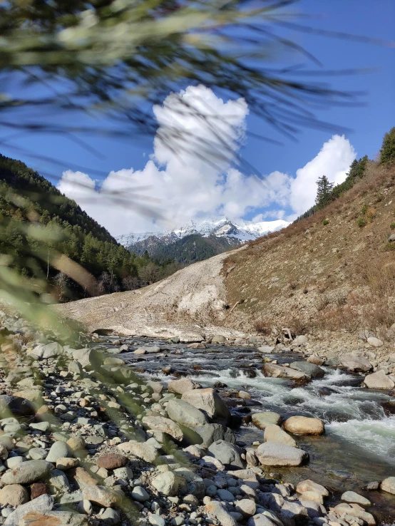 a stream in the middle of a rocky valley