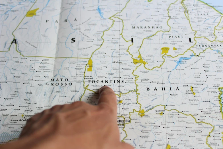 a person pointing to the map on a sheet of paper