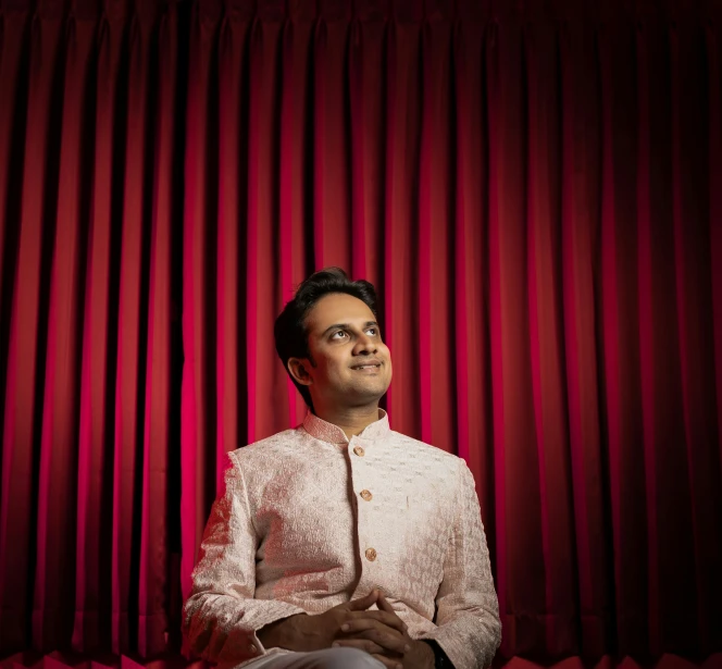 man dressed in white sitting on red couch