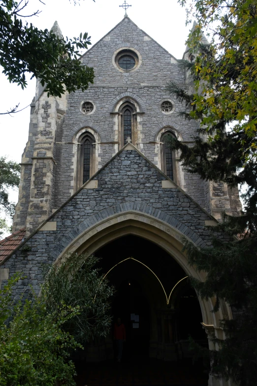 a brick church with two bells and a clock tower on top
