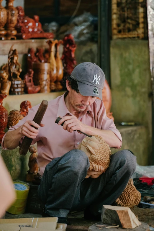 a man holding two wood handled shears while working on soing