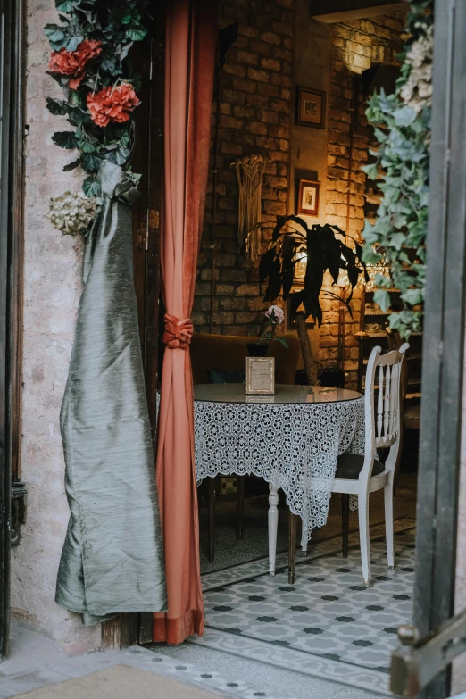 a table with white chairs and pink curtains