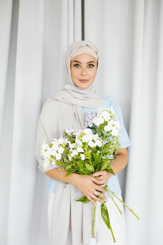 an attractive woman holding some white flowers