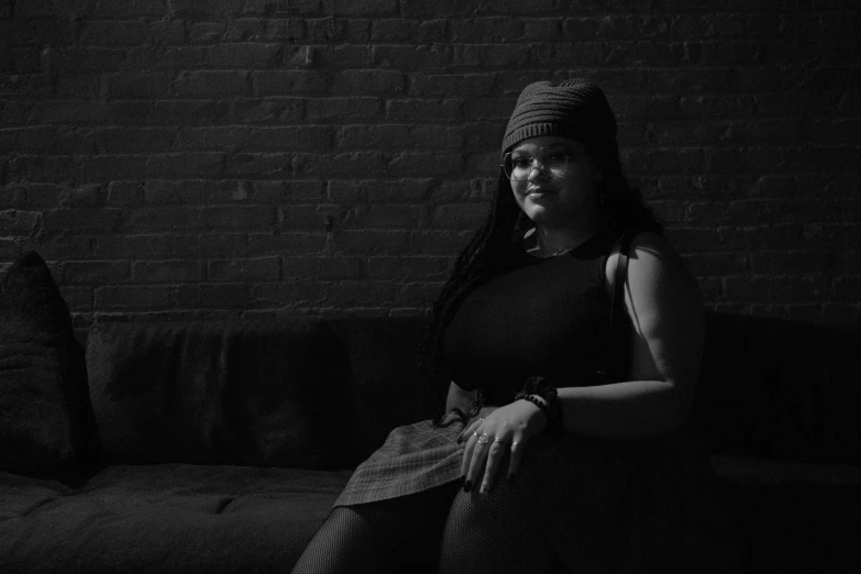 a woman sitting on a couch wearing a knit hat