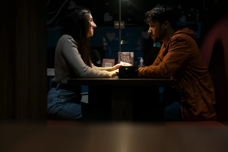 couple in dark restaurant, looking into each others eyes