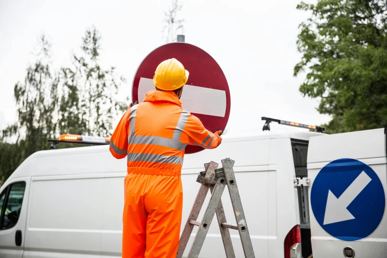 a man standing on a ladder next to a van