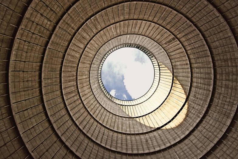looking up at a large spiral shaped brick structure with windows