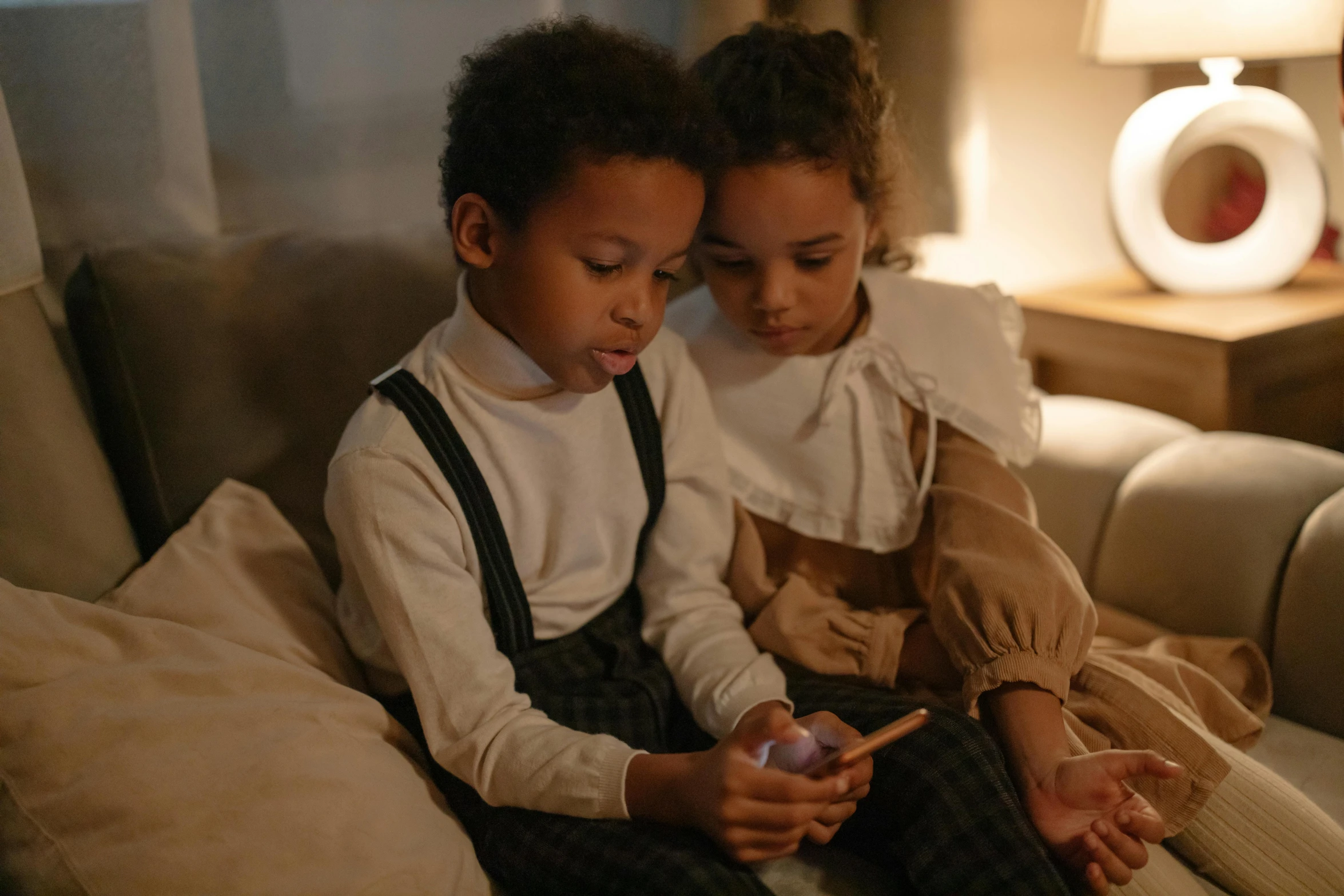 two children sitting next to each other on a couch