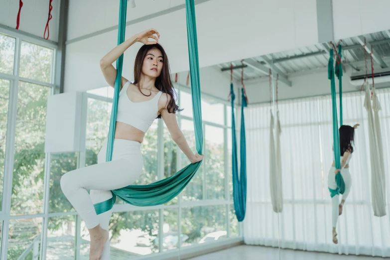 a woman standing on a green and white hammock