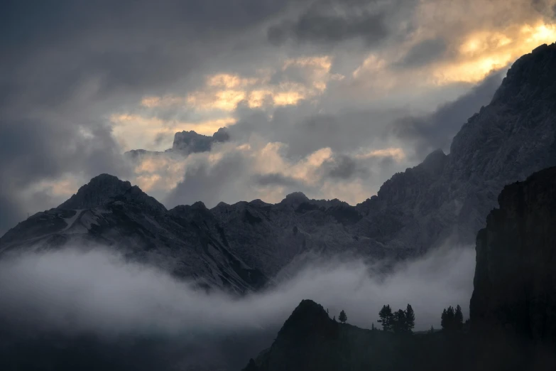 the clouds are rolling through the mountains in the valley